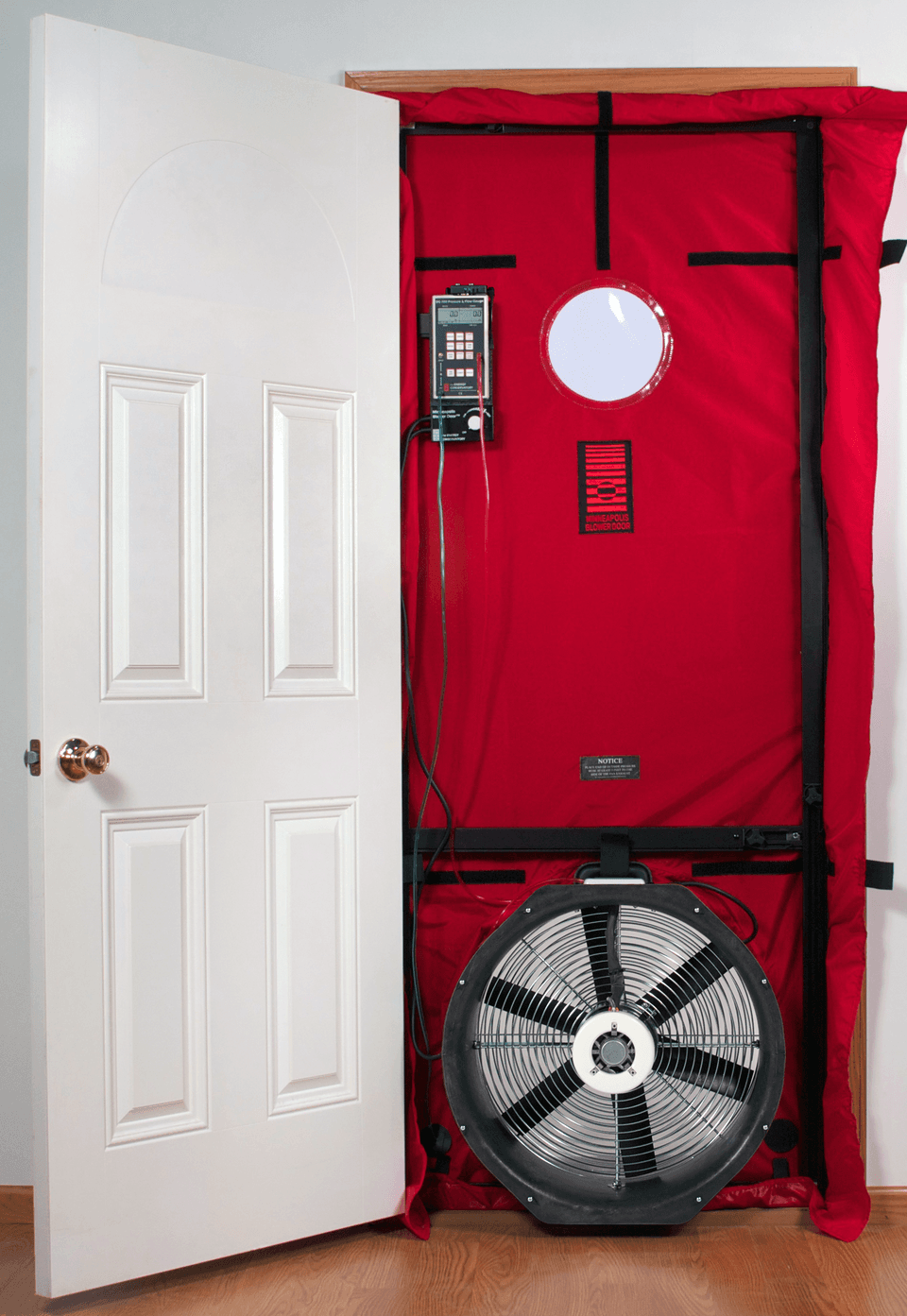 A blower door fan installed in an exterior doorway to test building airtightness.