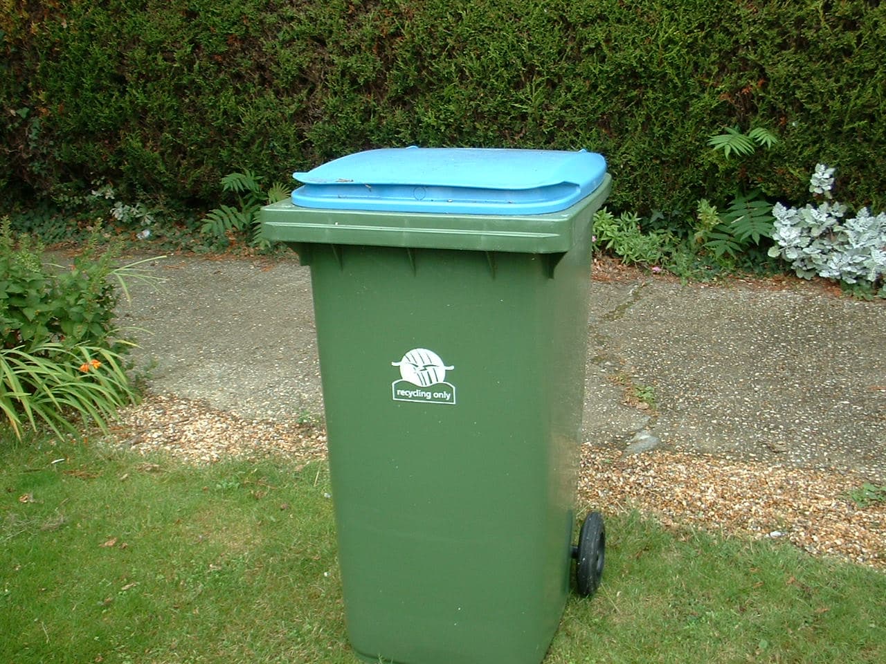 A blue recycling bin with the recycling symbol printed on the front.